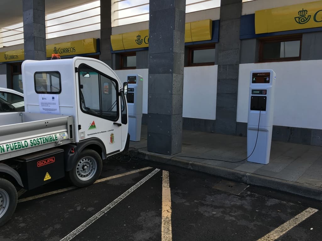 pequeño camión blanco eléctrico repostando energía.