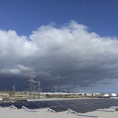 paneles solares cubriendo toda la superficie de techo. Al fondo cielo con nubes densas