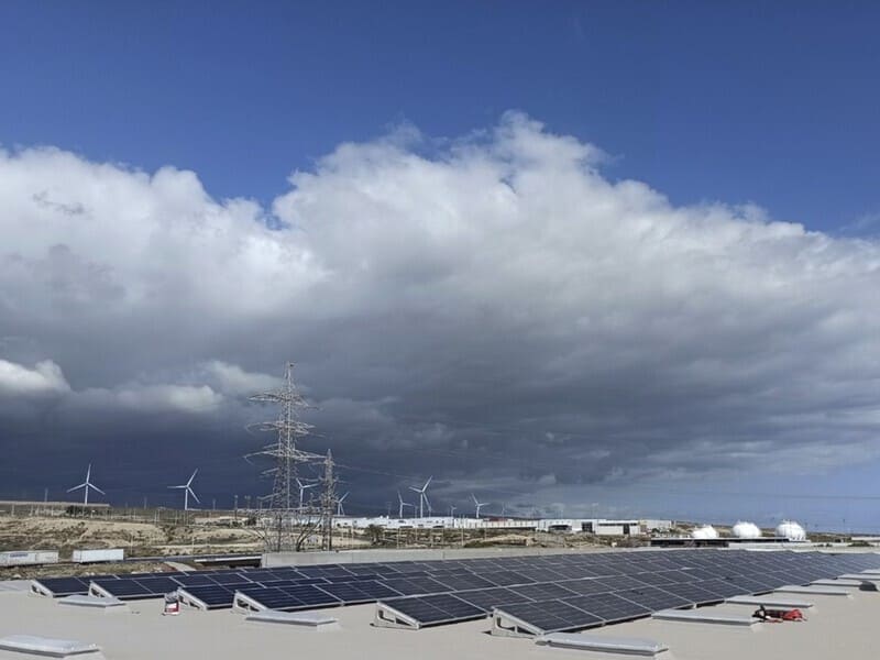paneles solares cubriendo toda la superficie de techo. Al fondo cielo con nubes densas