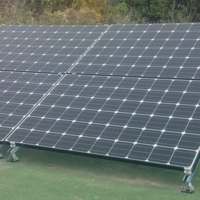 imagen de cuatro paneles solares sobre suelo verde color césped artifical